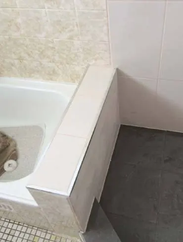 A tiled bath surround and hob