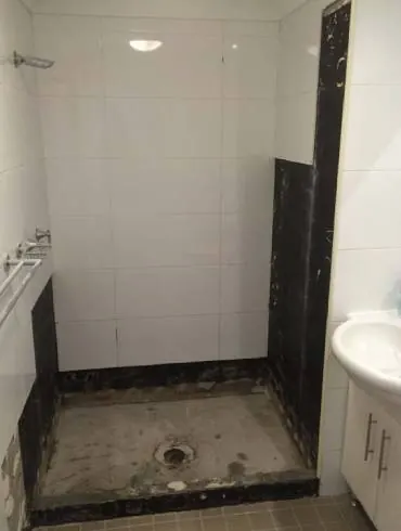 A shower recess stripped back to its base during a repair