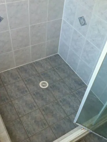 The same shower floor with clean new grout