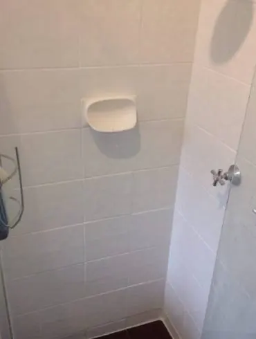 The white-tiled corner of a shower recess